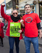 Two AEU members at a rally, both wearing red t-shirts. The member on the left carries a placard which says 'a fair go for all children'.
